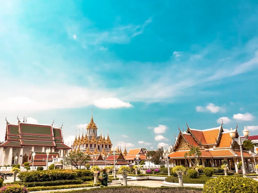 Templos de telhado alaranjado sob o sol, em Bangkok