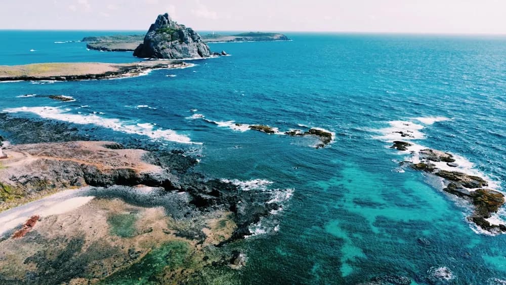 Formações rochosas cercadas por mar azul em Fernando de Noronha