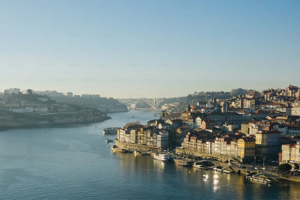 Barcos rabelos no rio Douro diante do casario do Porto