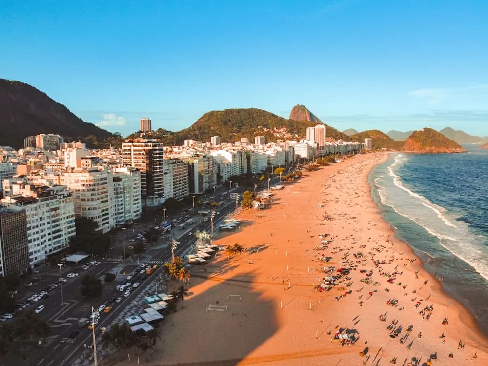 Praia de Copacabana ao entardecer com o calçadão e o mar